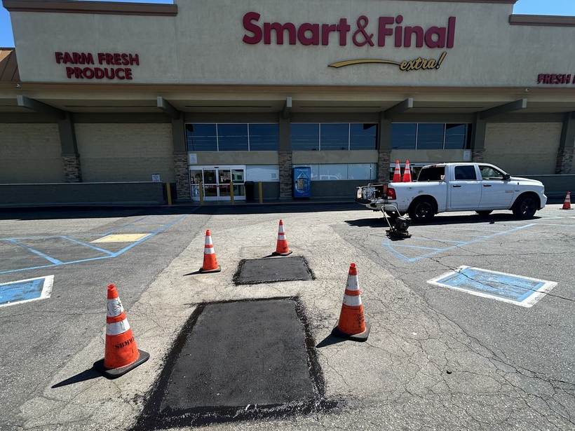 Saw-cut asphalt patches compacted in an open retail parking lot