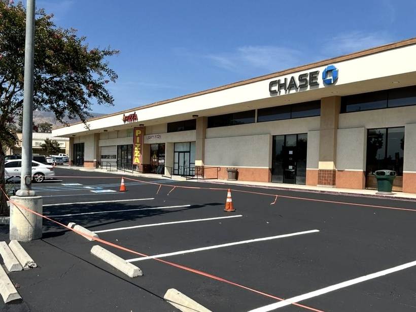 Neighborhood retail center lot with new seal coat and wheel stops