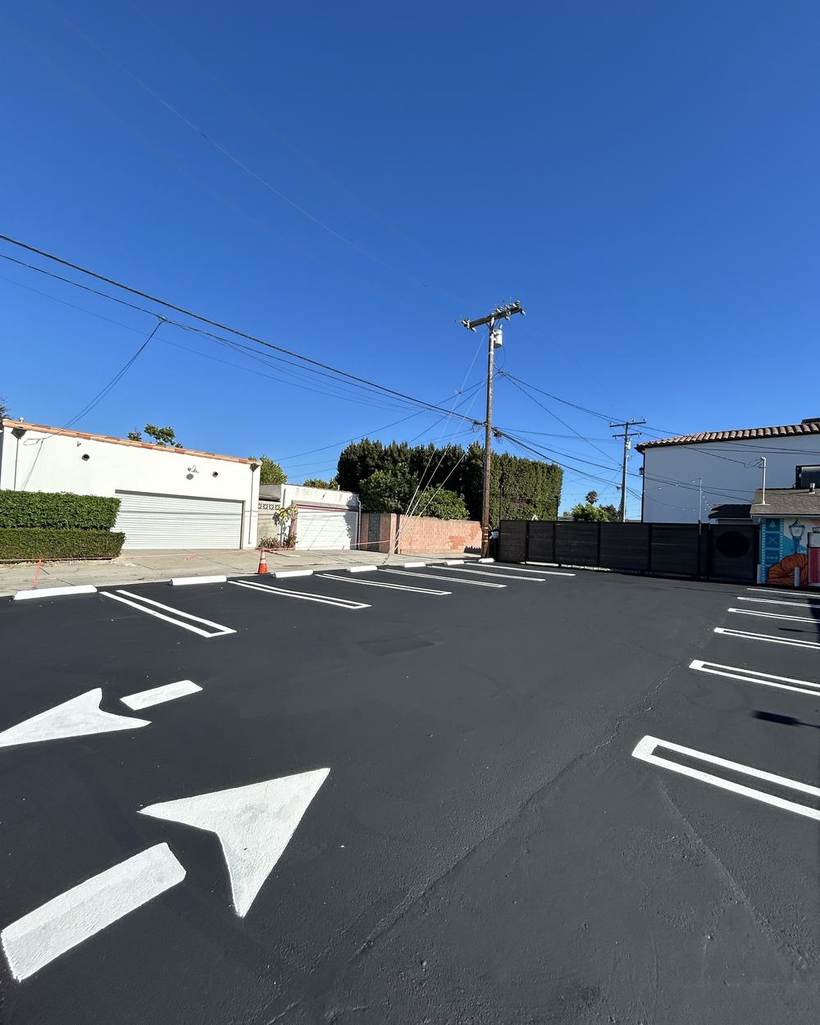 Small commercial lot finished with fresh seal coat, stalls and directional arrows
